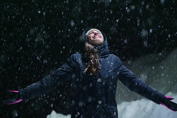 雪が空から降ってくると 夜になると美しい女性が光の中で立ち上がり きれいな空気を呼吸して自然の中で踊り始めます — ストック写真