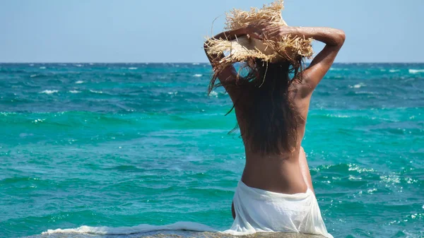Uma Mulher Está Sobre Rochas Mar Chapéu Palha Vestido Branco — Fotografia de Stock