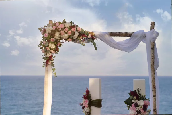 Portrait of a decorated arch of a wedding with the sea in the background.