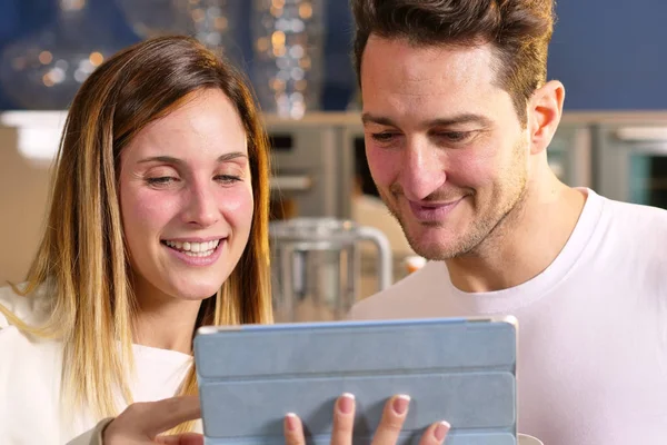 Casal Cozinha Olha Para Tablet Com Fotos Lembrança Suas Férias — Fotografia de Stock