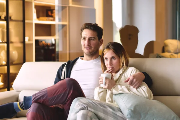 一对情侣看电视拥抱在新房子的沙发上 一起看电影 — 图库照片