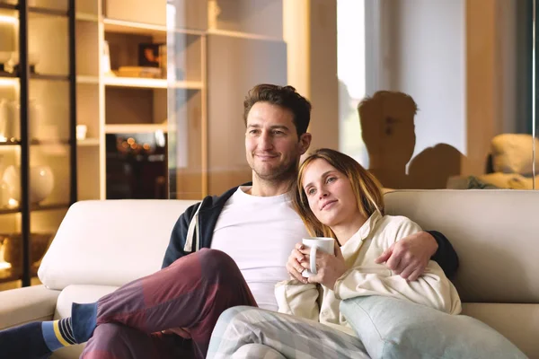一对情侣看电视拥抱在新房子的沙发上 一起看电影 — 图库照片