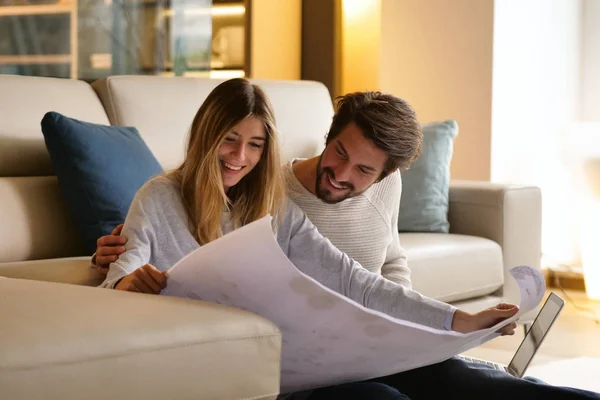 couple in love planning new home furniture while sitting on floor at sofa