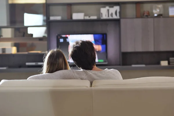 Paio Amanti Guardano Televisione Abbracciata Sul Divano Della Nuova Casa — Foto Stock