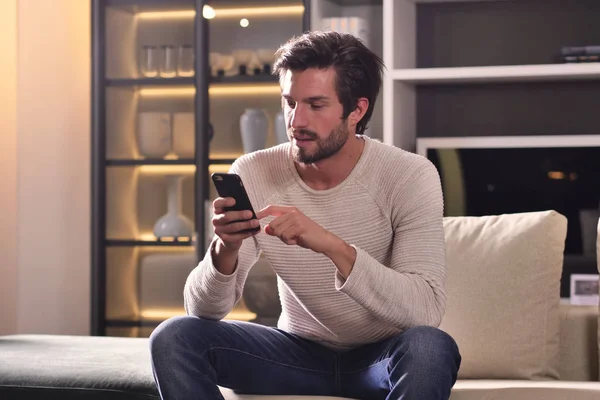 Seorang Pria Sofa Mengirimkan Pesan Atau Panggilan Dengan Telepon Dan — Stok Foto