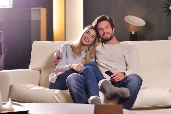 Een Paar Liefhebbers Omarmd Sofa Het Nieuwe Huis Televisie Kijken — Stockfoto