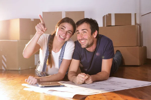 Pareja Enamorada Tumbada Suelo Madera Con Plano Habitación Tableta Digital —  Fotos de Stock