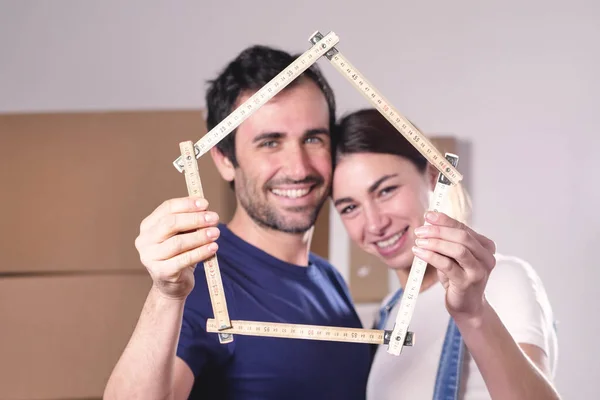 Feliz Casal Sorridente Amor Segurando Casa Forma Metro Nas Mãos — Fotografia de Stock