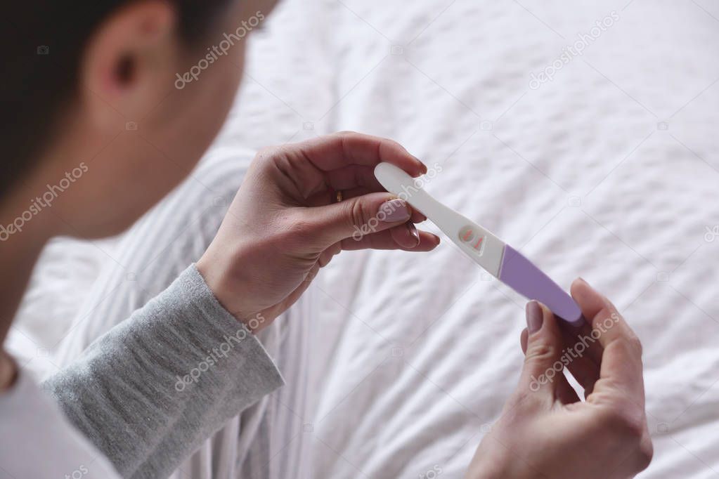A beautiful woman takes a pregnancy test and as soon as she reads that she is pregnant, she explodes in a moment of happiness and joy for the future birth of her child. Concept of: birth, life, family