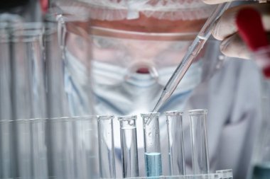 Fütüristik bir doktor, cerrah, teknolojik bir dijital holografik tabak, tıbbi maske, bir kap, kahverengi gözleri inceliyor. Konsept: futuristik tıp, yeni teknolojiler, doktorlar, laboratuvar, gelecek.