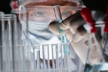 Fütüristik bir doktor, cerrah, teknolojik bir dijital holografik tabak, tıbbi maske, bir kap, kahverengi gözleri inceliyor. Konsept: futuristik tıp, yeni teknolojiler, doktorlar, laboratuvar, gelecek.