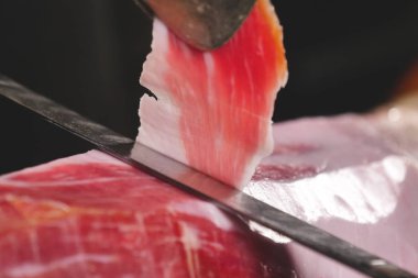 Makro bir dilim jambon, mükemmel kalitede, geleneğe göre bıçakla kesen bir şefin kapatın. Jambon, kavramı gıda, İspanya ve İtalya, yemek tedarik.