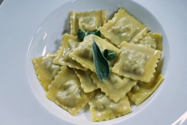 Bir şef İtalyan Mantısı ile taze ev yapımı makarna yapılan oluşan taze pişmiş yemek süsleyen. Kavramı: restaurant, gurme, İtalya, mantı