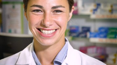 Güzel genç kız (kadın) eczacı, danışman, satış ve ilaç, kontrol bir eczanede çalışan gülümseyerek, tavsiyede portresi. Konsept: meslek, tıp, tıp eğitimi.