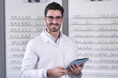 Optik center ve tarama dijital tablet göz giyen yakışıklı beyaz adam gözlük 