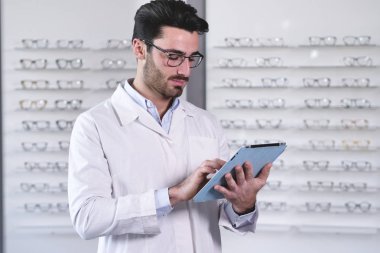 Optik center ve tarama dijital tablet göz giyen yakışıklı beyaz adam gözlük 