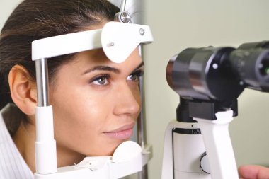 woman checking eyes, Slit lamp examination of eyes in ophthalmology clinic clipart