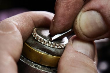 Bir kuyumcu'nın el yapım bir altın veya gümüş yüzük ya da bir elmas kuyumcu'nın araçlarını kullanarak kapatın. Bu iş için hassas ve sabır alır. Kavramı: gelenek, lüks, takı.