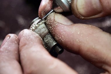 Bir kuyumcu'nın el yapım bir altın veya gümüş yüzük ya da bir elmas kuyumcu'nın araçlarını kullanarak kapatın. Bu iş için hassas ve sabır alır. Kavramı: gelenek, lüks, takı.