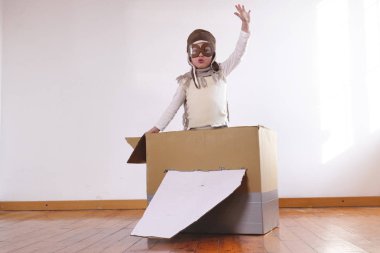 küçük çocuk çocuk pilot evde el yapımı kağıt uçak ile oynarken olarak giyinmiş