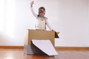 küçük çocuk çocuk pilot evde el yapımı kağıt uçak ile oynarken olarak giyinmiş