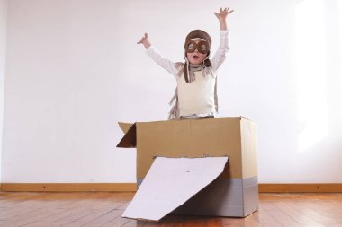 küçük çocuk çocuk pilot evde el yapımı kağıt uçak ile oynarken olarak giyinmiş