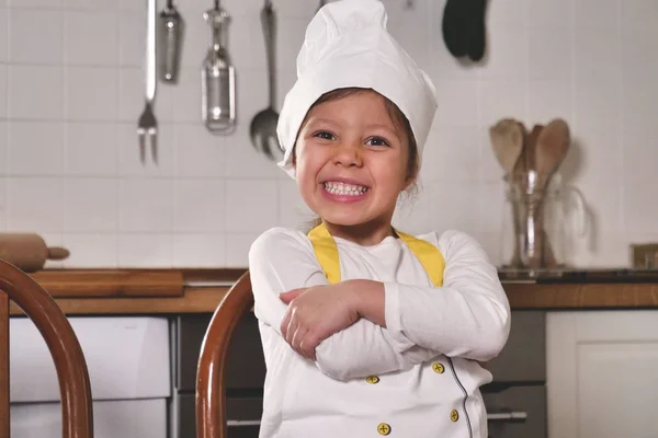 厨房里一个小女孩的画像 打扮成一个专业的厨师玩面粉 弄脏了她的手 笑得很开心 烹饪学校 教育和游戏概念 — 图库照片
