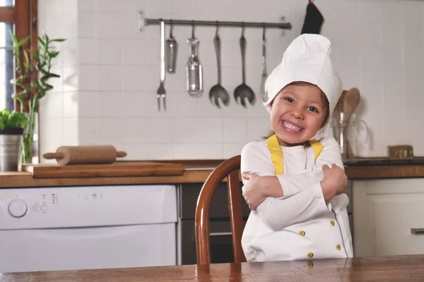 厨房里一个小女孩的画像 打扮成一个专业的厨师玩面粉 弄脏了她的手 笑得很开心 烹饪学校 教育和游戏概念 — 图库照片