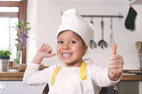 厨房里一个小女孩的肖像 打扮成一个专业的厨师 用她的手做确定 作为适当营养和正宗食物的标志 烹饪学校 — 图库照片