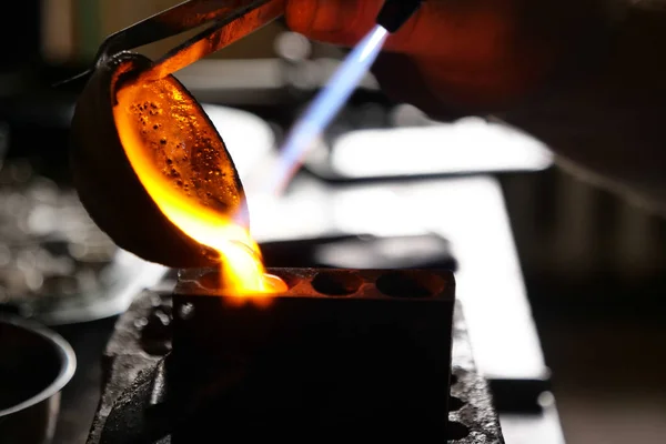A goldsmith melts the gold with the oxydric flame to create precious rings to sell. Concept of: craftsmanship, tradition and luxury craftsmanship.