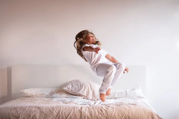Une Petite Fille Pyjama Blanc Saute Sur Lit Amuse Concept — Photo