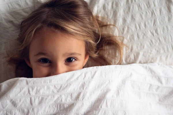 Portrait Une Petite Fille Sous Les Couvertures Blanches Souriant Regardant — Photo