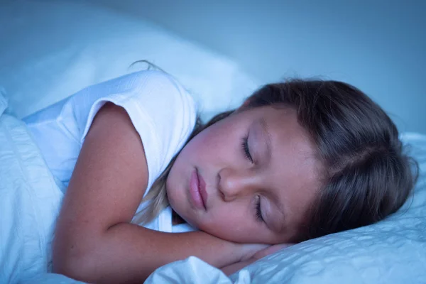 一个美丽的女孩睡觉 并有安静的梦想 在她的白色床上覆盖着毯子 这个女孩笑了 因为她很放松 睡得很好 爱睡觉 — 图库照片