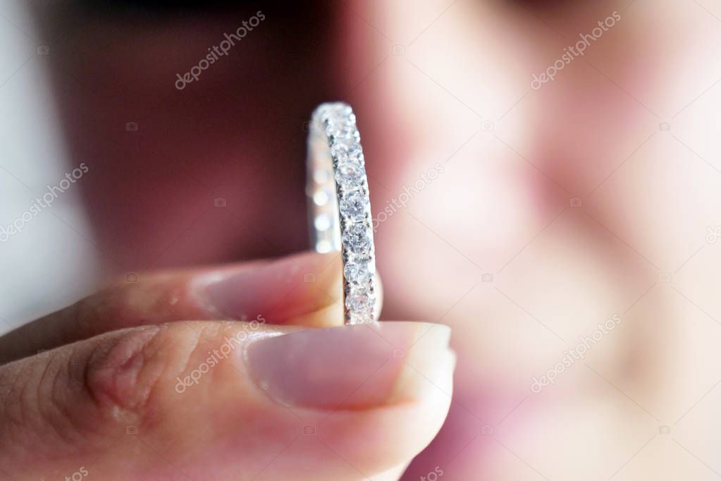 Close-up of a beautiful hand of a woman wearing a precious diamond ring. Concept of: wedding, luxury, jewelry.