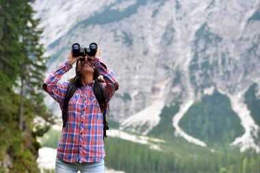Kamp, güzel bir kadın onun etrafında doğa hayvan veya gitmek için yollar aramak için dürbün ile keşfedin. Kavramı: merak, araştırma, keşif, trekking
