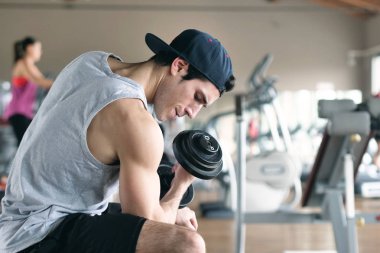 Bir tank top bir spor salonunda bir adam, vücudu fit kalmak ve kasları tanımlamış olduğunuz için eğitiyor. Atlet ağır ağırlık ve yorgunluk yükseltir. Kavramı: spor, spor salonu, kas ve fitness
