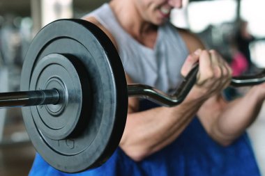 Bir tank top bir spor salonunda bir adam, vücudu fit kalmak ve kasları tanımlamış olduğunuz için eğitiyor. Atlet ağır ağırlık ve yorgunluk yükseltir. Kavramı: spor, spor salonu, kas ve fitness