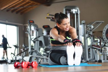 Spor malzemeleri ve formda kalmak ve tonda için ücretsiz vücut salonunda güzel bir gülümseyen kadın eğitiyor. Kavramı: eğitim, sağlık, spor, spor salonu, diyet.