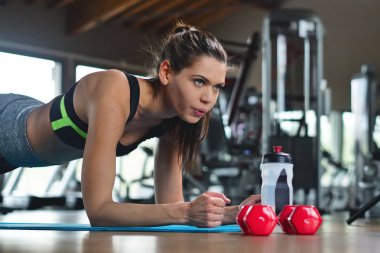 Spor malzemeleri ve formda kalmak ve tonda için ücretsiz vücut salonunda güzel bir gülümseyen kadın eğitiyor. Kavramı: eğitim, sağlık, spor, spor salonu, diyet.
