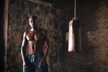 kameraya poz ve kum torbası ayakta ciddi yakışıklı gömleksiz kas boksör Afrika adam 