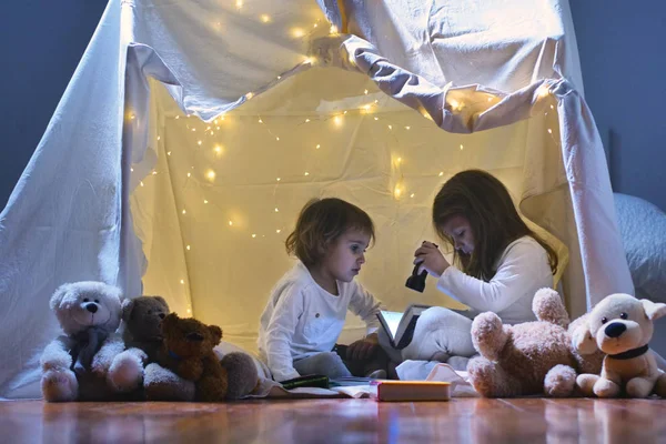 Zwei Kleine Mädchen Spielen Abends Hause Ein Zeltlager Aufzubauen Bücher — Stockfoto