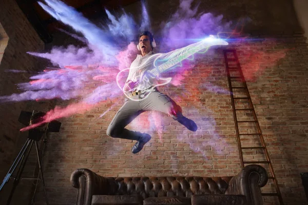 man jumps with colorful background playing a virtual guitar. concept of freedom and creativity with music