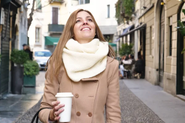 彼女はアメリカのコーヒーを飲むし 彼女は買い物に行くしている場合彼女の手で袋を保持して間 優雅さ 服を着たキャリアウーマンを都市の通りを通って歩きます 実業家 — ストック写真