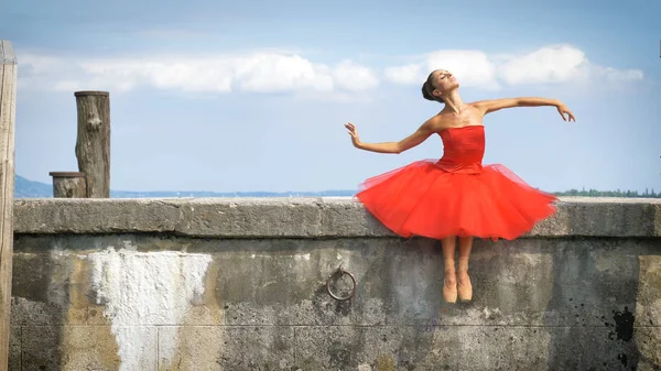 Kaunis Vaalean Ballerinan Muotokuva Rehevässä Punaisessa Mekossa Istuu Kivilaiturilla Hellä — kuvapankkivalokuva