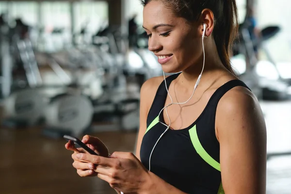 Une Belle Jeune Femme Sourit Lisant Message Écoutant Musique Gymnase — Photo