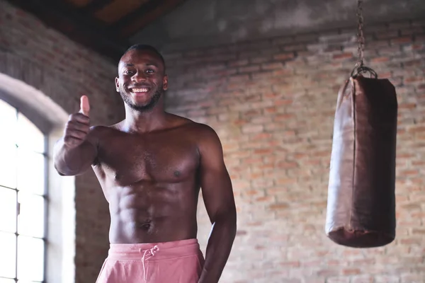微笑的无袖肌肉拳击手非洲男子站在打气筒和示意竖起大拇指 — 图库照片
