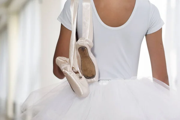 一个漂亮女孩的肖像 在一所舞蹈学校 穿着白色的短裙 拿着她用来训练的鞋子 热爱舞蹈 — 图库照片