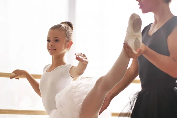 一位古典舞蹈老师教他的年轻学生一些步骤 他们想学习如何跳舞 背景是其他听的小女孩 — 图库照片