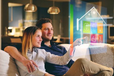 Bir çift kanepede oturan ev wi-fi, Isıtma, aydınlatma, holografi üzerinden televizyon gibi tüm fonksiyonlarını kontrol eder. Kavramı, ev otomasyon, otomasyon sistemleri, gelecek, teknoloji.