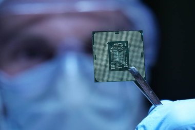 Ultra Modern elektronik imalat fabrikası tasarım mühendisi olarak steril Coverall tutan mikro yongasında fütüristik holografi, Internet cyber security sembolleri ile.